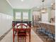 Open-concept dining room featuring stylish light fixture, bar seating, and stainless steel appliances at 1318 Encore Ln, Waxhaw, NC 28173
