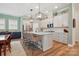 Bright kitchen featuring an island with seating, stainless steel appliances, and modern light fixtures at 1318 Encore Ln, Waxhaw, NC 28173