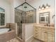 This bathroom features a soaking tub, a glass shower with rain head, and a vanity sink with drawers at 1404 Lookout Cir, Waxhaw, NC 28173