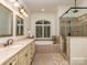 This bathroom features a soaking tub under a window, a glass shower, and double vanity sinks at 1404 Lookout Cir, Waxhaw, NC 28173