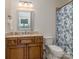 Well-lit bathroom featuring a wood vanity, framed mirror, and a patterned shower curtain at 1404 Lookout Cir, Waxhaw, NC 28173