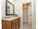 Well-lit bathroom featuring a wood vanity, framed mirror, and tiled floors at 1404 Lookout Cir, Waxhaw, NC 28173