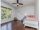 Bright bedroom with hardwood floors, a ceiling fan, and a large window at 1404 Lookout Cir, Waxhaw, NC 28173