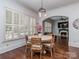 Bright dining area with shuttered windows, wood table, and hardwood flooring at 1404 Lookout Cir, Waxhaw, NC 28173