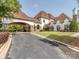 Elegant home exterior featuring a porte-cochere, manicured lawn, and lush landscaping at 1404 Lookout Cir, Waxhaw, NC 28173