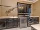 Laundry room with front loading washer and dryer, black cabinets and a sink at 1404 Lookout Cir, Waxhaw, NC 28173