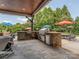 Outdoor kitchen featuring stone surround, stainless steel appliances, and a built-in grill near pool at 1404 Lookout Cir, Waxhaw, NC 28173
