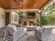 Inviting outdoor living area with stone fireplace, mounted tv, wood ceiling and comfortable seating at 1404 Lookout Cir, Waxhaw, NC 28173