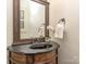 Powder room with carved wood cabinet and black marble sink at 1404 Lookout Cir, Waxhaw, NC 28173