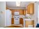 Cozy kitchen featuring wooden cabinetry, white appliances, and a double sink for meal prep at 15042 Deshler Ct, Charlotte, NC 28273