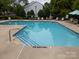 Community pool features lounge chairs, tables, and shade for residents at 15042 Deshler Ct, Charlotte, NC 28273