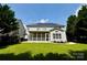 Expansive backyard with a lush lawn, mature trees, a screened porch, and solar panels at 16012 Caranna Ct, Charlotte, NC 28277