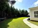 A spacious backyard featuring a lush lawn, pathway, and tall evergreen trees providing privacy at 16012 Caranna Ct, Charlotte, NC 28277