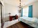 Inviting bedroom with hardwood flooring, bright blue curtains and a modern chandelier fixture at 16012 Caranna Ct, Charlotte, NC 28277