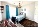 Comfortable bedroom features hardwood floors, blue accent curtains, and a modern chandelier at 16012 Caranna Ct, Charlotte, NC 28277