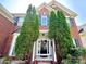 Close-up of the brick home's front door, framed by lush greenery and mature landscaping at 16012 Caranna Ct, Charlotte, NC 28277