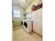 Well-lit laundry room features tile flooring, modern washer/dryer, and ample storage shelving and cabinets at 16012 Caranna Ct, Charlotte, NC 28277