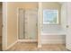 Bright bathroom featuring shower stall, soaking tub, tile floors, and natural light at 170 Glenn Allen Rd, Mooresville, NC 28115