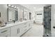 This is a well lit spacious modern bathroom with 2 large mirrors and double sinks at 17101 Windy Oaks Ct, Cornelius, NC 28031