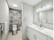 Modern bathroom features grey marble in shower, sleek sink with large vanity mirror and white cabinets at 17101 Windy Oaks Ct, Cornelius, NC 28031