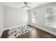 Bright bedroom with hardwood floors, a ceiling fan, and natural light from two windows at 17101 Windy Oaks Ct, Cornelius, NC 28031