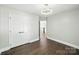 This bedroom features hardwood floors, overhead lighting, closet and view into the hallway and stairs at 17101 Windy Oaks Ct, Cornelius, NC 28031