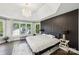 Spacious main bedroom featuring a tray ceiling, hardwood floors, a large window, and modern lighting at 17101 Windy Oaks Ct, Cornelius, NC 28031