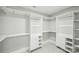 This large walk-in closet features white shelving, drawers, and hardwood floors at 17101 Windy Oaks Ct, Cornelius, NC 28031