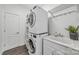 Clean laundry room features stacked washer/dryer, utility sink and folding area at 1905 Tranquility Blvd, Lancaster, SC 29720