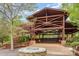 An outdoor pavilion with timber framing with a stone fire pit and deck seating at 1905 Tranquility Blvd, Lancaster, SC 29720