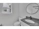 Bathroom featuring a modern sink, toilet, a gray countertop, and a round mirror at 1933 St Mark St, Charlotte, NC 28216