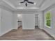 Bedroom featuring a ceiling fan, wood-look floors, and doorways leading to a bathroom and closet at 1933 St Mark St, Charlotte, NC 28216