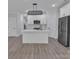 Bright open-concept kitchen featuring a white island and cabinets, stainless steel appliances, and a modern light fixture at 1933 St Mark St, Charlotte, NC 28216