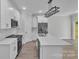 Modern kitchen with white cabinets, an island with a sink, stainless steel appliances, and sleek black fixtures at 1933 St Mark St, Charlotte, NC 28216