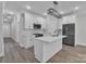 Modern white kitchen featuring an island, stainless steel appliances, and a sleek, minimalist lighting fixture at 1933 St Mark St, Charlotte, NC 28216