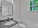 Modern bathroom with a gray vanity, sleek mirror, and a window offering natural light at 1935 St Mark St, Charlotte, NC 28216