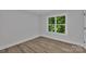 A bright and airy bedroom with a large window overlooking lush greenery and hardwood floors at 1935 St Mark St, Charlotte, NC 28216
