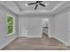 A spacious main bedroom with hardwood floors, a ceiling fan, and an ensuite bathroom at 1935 St Mark St, Charlotte, NC 28216