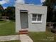 Outbuilding with painted cinder blocks, white trim, a window, front door and brick steps at 209 Barber Rd, Gastonia, NC 28056