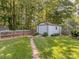 Well-maintained backyard with lush green grass, stone path, and detached shed for storage at 214 Wilcrest Dr, Matthews, NC 28105