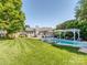 Expansive backyard featuring an in-ground pool, pergola, and lush lawn at 214 Wilcrest Dr, Matthews, NC 28105
