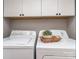 Bright laundry room featuring a white washer and dryer plus convenient storage cabinets above at 214 Wilcrest Dr, Matthews, NC 28105