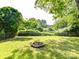Green backyard featuring a fire pit area, fence, and mature trees for a private outdoor space at 22 Walnut Nw Ave # 1, Concord, NC 28027