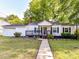 Charming home featuring a covered front porch, a well-maintained lawn, and mature trees at 22 Walnut Nw Ave # 1, Concord, NC 28027