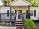 Close up of the covered front porch with wooden railings and a painted front door at 22 Walnut Nw Ave # 1, Concord, NC 28027