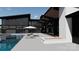Modern home exterior with a pool, patio with lounge chairs, and outdoor fire pit at 22554 John Gamble Rd, Cornelius, NC 28031