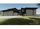 Modern home exterior featuring a sleek design, three-car garage and meticulous landscaping at 22554 John Gamble Rd, Cornelius, NC 28031