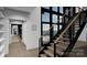Modern staircase featuring minimalist design, wood steps, black metal railings and large window at 22554 John Gamble Rd, Cornelius, NC 28031