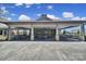 Covered outdoor seating area with stone accents, ample tables, and a built-in grill, perfect for entertaining at 2364 Delaney Dr, Fort Mill, SC 29715