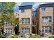 Rear exterior view of the townhome featuring brick facade and a small balcony on the second level at 243 Lincoln St, Charlotte, NC 28203
